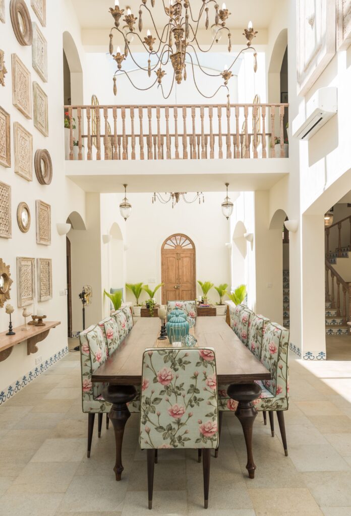 Luxurious dining room featuring floral-print chairs, chandelier, and artistic decor in a spacious villa.
